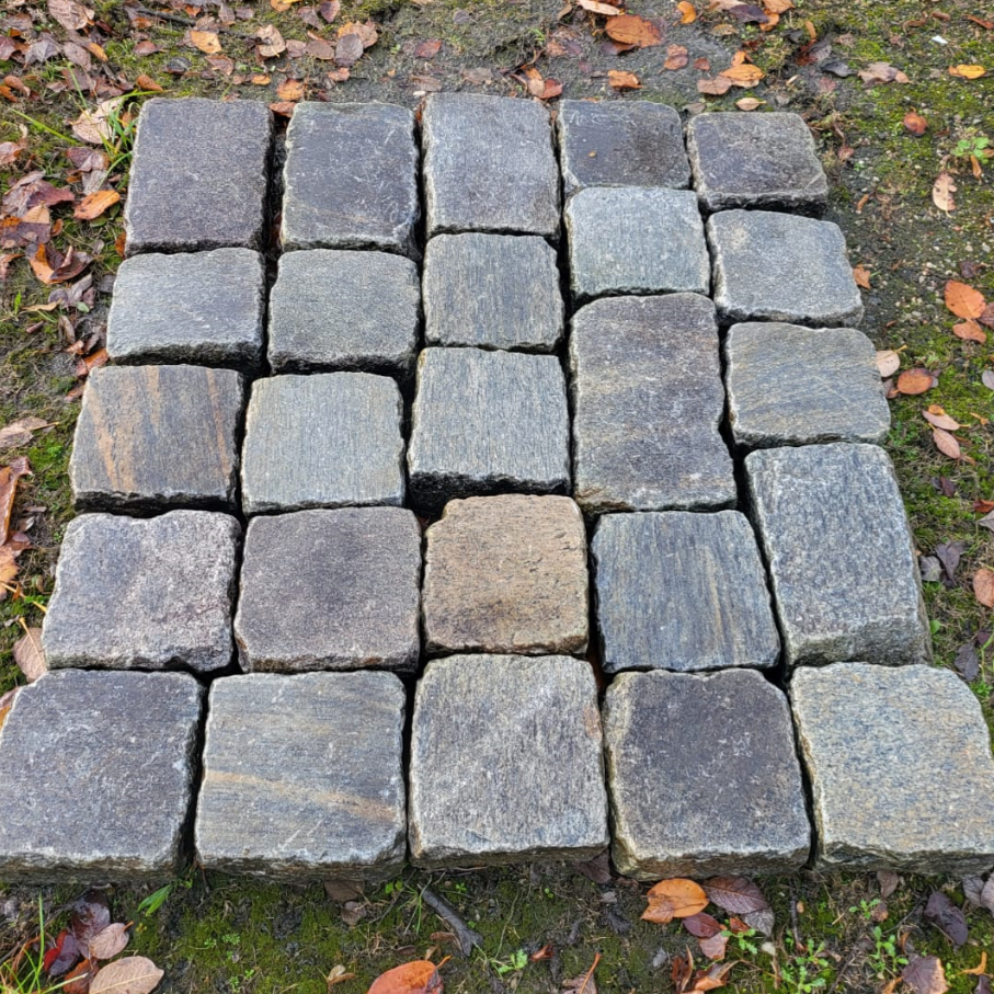 Geschnittene Pflasterkappen aus historischem Naturstein in Grautönen