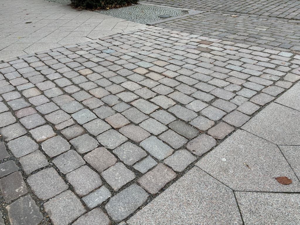 Nahaufnahme von historischem Natursteinpflaster in Handarbeit bearbeitet